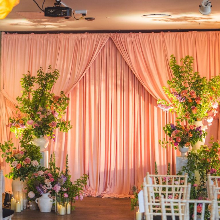 Soft pink wedding ceremony drapes backdrop at London venue using freestanding pipe and drape system