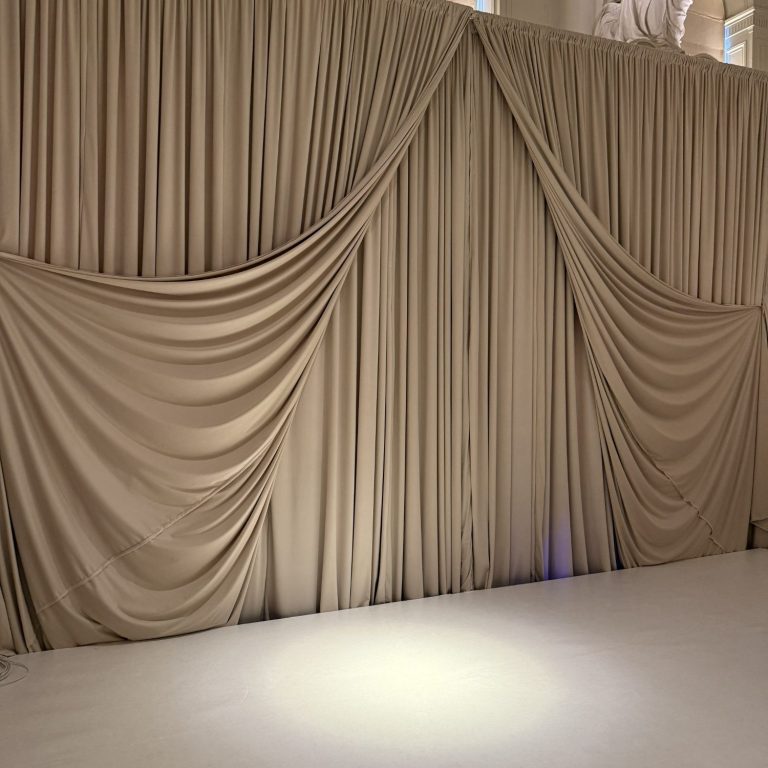 Velvet Wedding Drapes London – Backdrop Setup Velvet wedding drapes in London used as backdrop behind top table with freestanding pipe and drape system