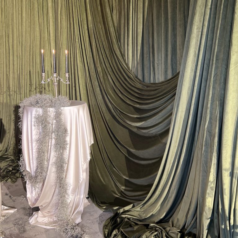 Green velvet wedding drapes in London creating a rich backdrop using freestanding pipe and drape system